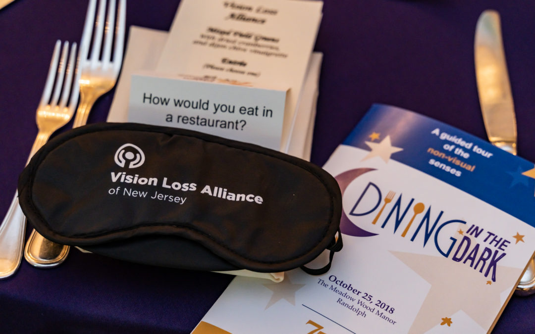 This is a place setting from our Dining in the Dark event. It features utensils, a folded napking, an event program, occluders and a probing question for discussion.