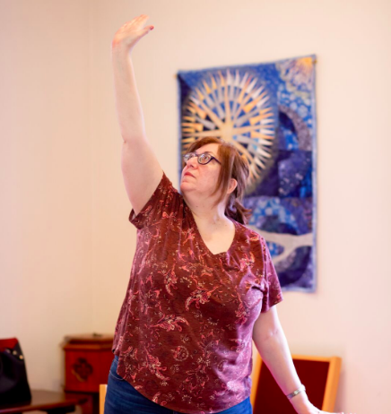 Person standing in a room, doing a yoga pose