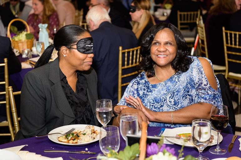 Two women dining, person on left is wearing learning shades