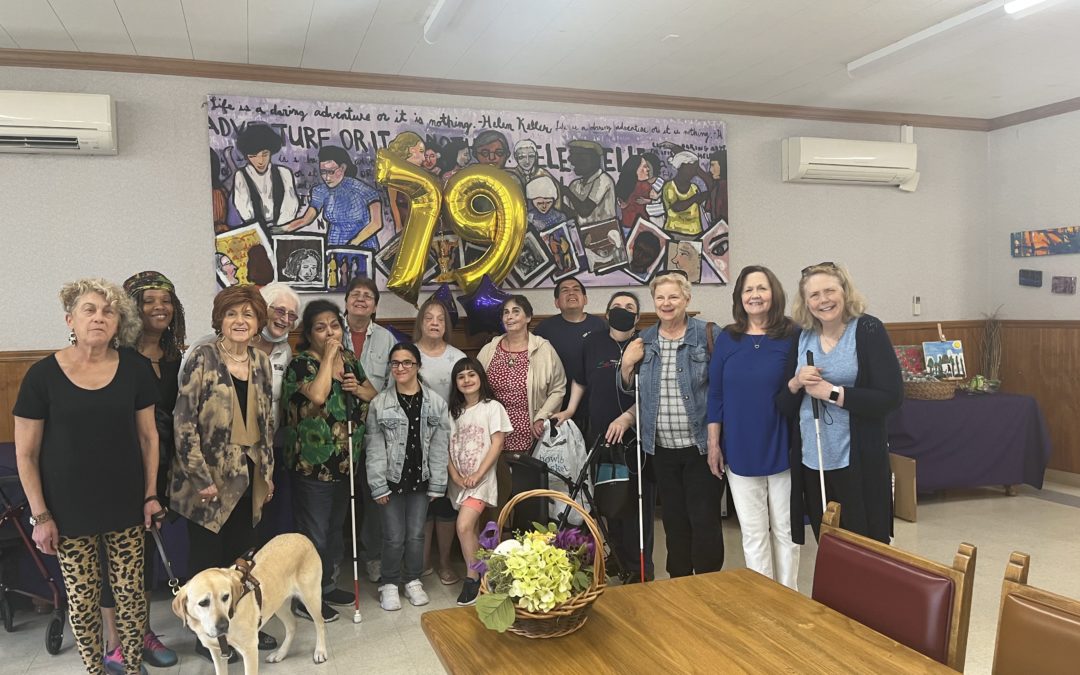 VLANJ program participants gather at VLANJ's Denville location in front of balloons that say "79."