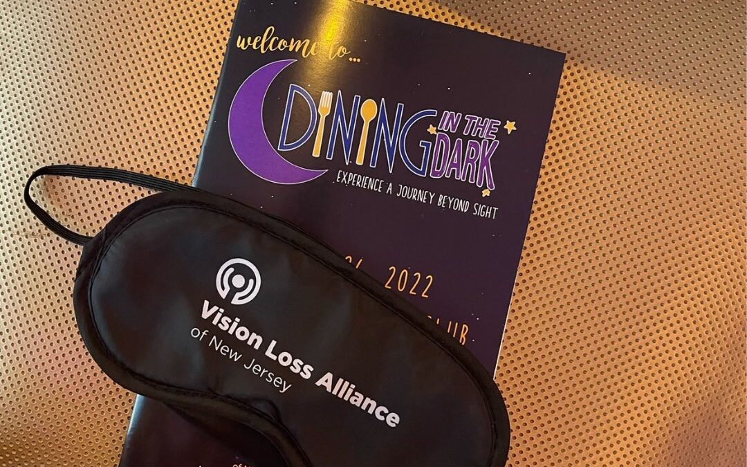 Dining in the Dark learning shades and a Dining in the Dark event program are featured on a chair.