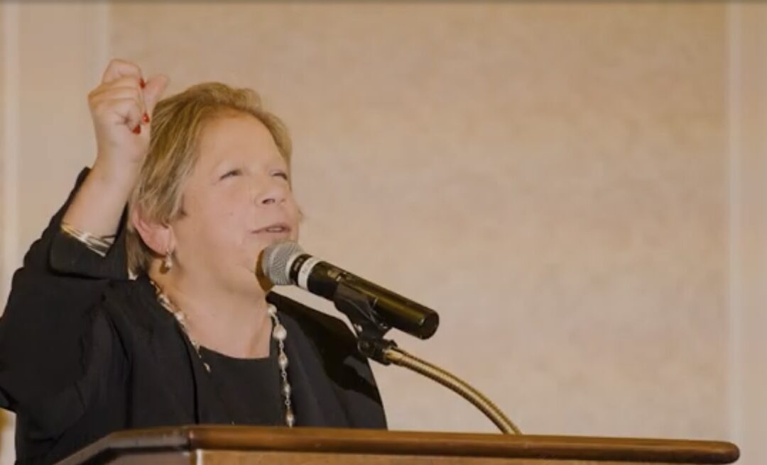 Claudia Schreiber speaks at a podium.